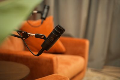 Audio Technica microfoon met oranje sofastoel op de achtergrond in Podcast Studio 010