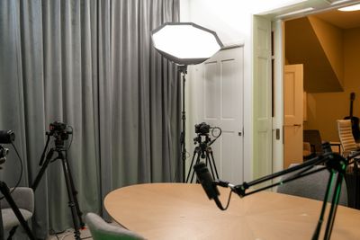 Volledig overzicht opnameruimte met camera's op statief, professionele verlichting en ronde tafel